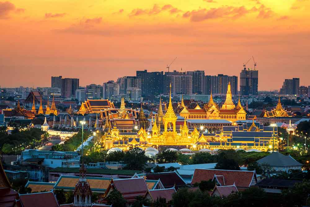 How to Spend a Month in Thailand: Best 1 Month in Thailand Itinerary 28 The Bangkok cityscape at sunset time showcases the illuminated gold Grand Palace, along with the surrounding houses and buildings