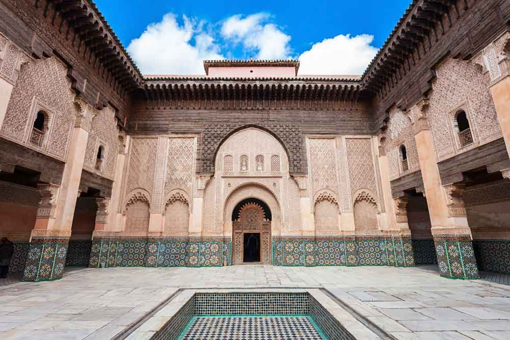 The historic Ben Youssef Madrasa, a must-visit for anyone wondering what to do in Marrakech. This former Islamic school features stunning Moroccan architecture, with intricate cedarwood carvings, colorful zellige tilework, and a peaceful central courtyard with a reflecting pool. Once the largest madrasa in North Africa, it offers a glimpse into the city's rich cultural and educational heritage