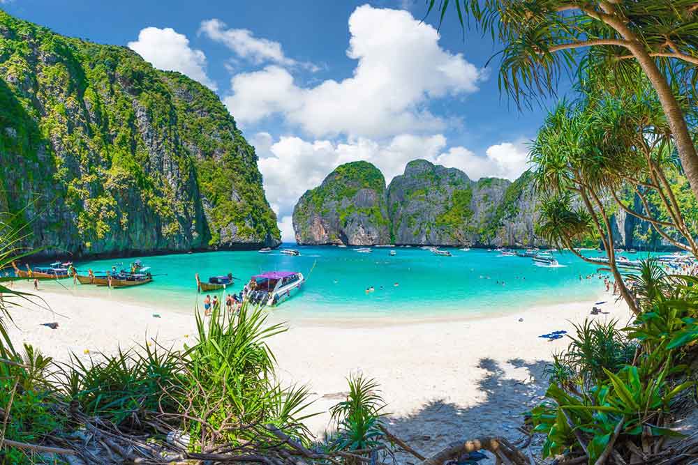 How to Spend a Month in Thailand: Best 1 Month in Thailand Itinerary 20 The beautiful blue sea water and sky of Maya Bay in Phi Phi, adorned with boats and palm trees