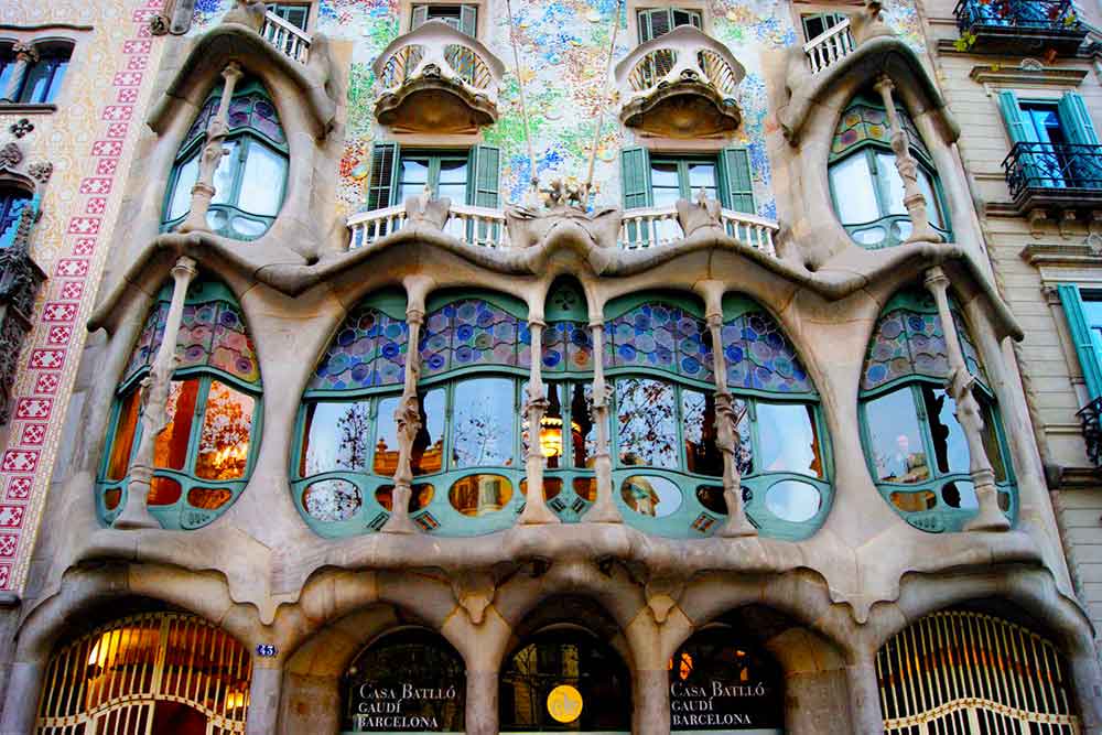 Front façade of Casa Batlló in Barcelona, showcasing Antoni Gaudí’s signature modernist style with curved windows, colourful tiles, and organic forms—an architectural highlight in Spain.