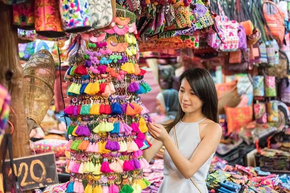 Is Bangkok Worth Visiting? 16 Great Reasons to Visit Bangkok 20 Young woman shopping for a souvenirs at Thailand Market