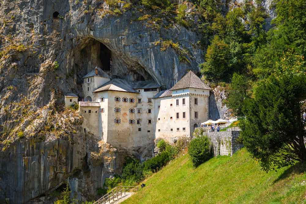 Predjama Castle, Slovenia - a remarkable castle that built right into a cave surrounded by stunning cliffs and green hills
