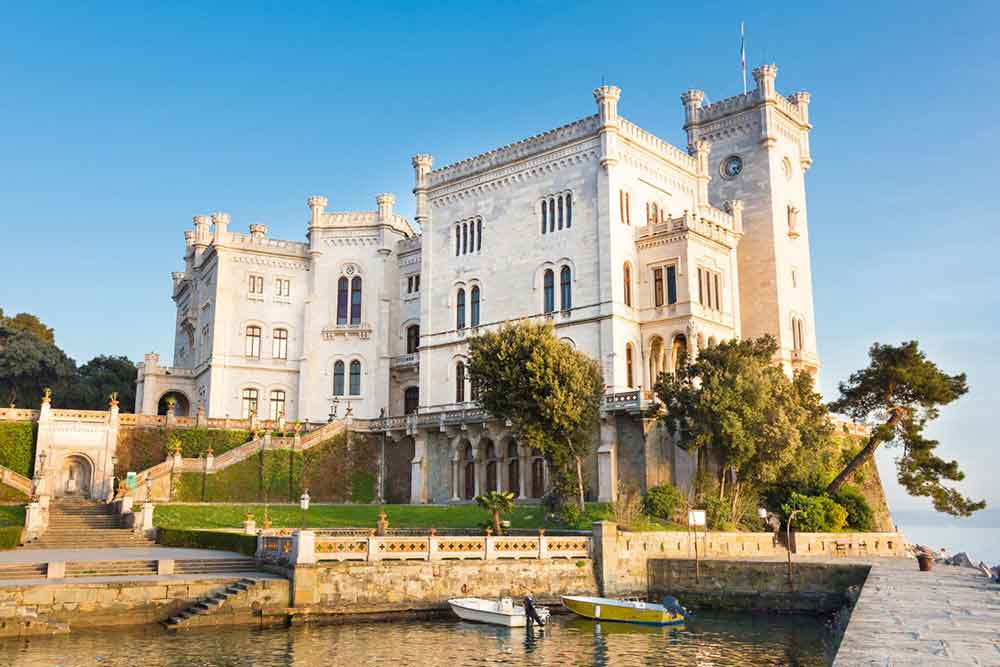 Miramare Castle in Italy - a stunning seaside palace surrounded by lush gardens with a breathtaking view of the azure waters of the Adriatic Sea