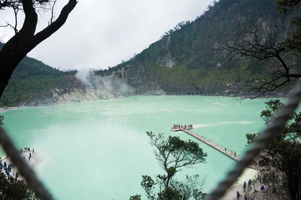Kawah Putih, Java featuring a vast crater lake with light blue water encircled by steep cliffs