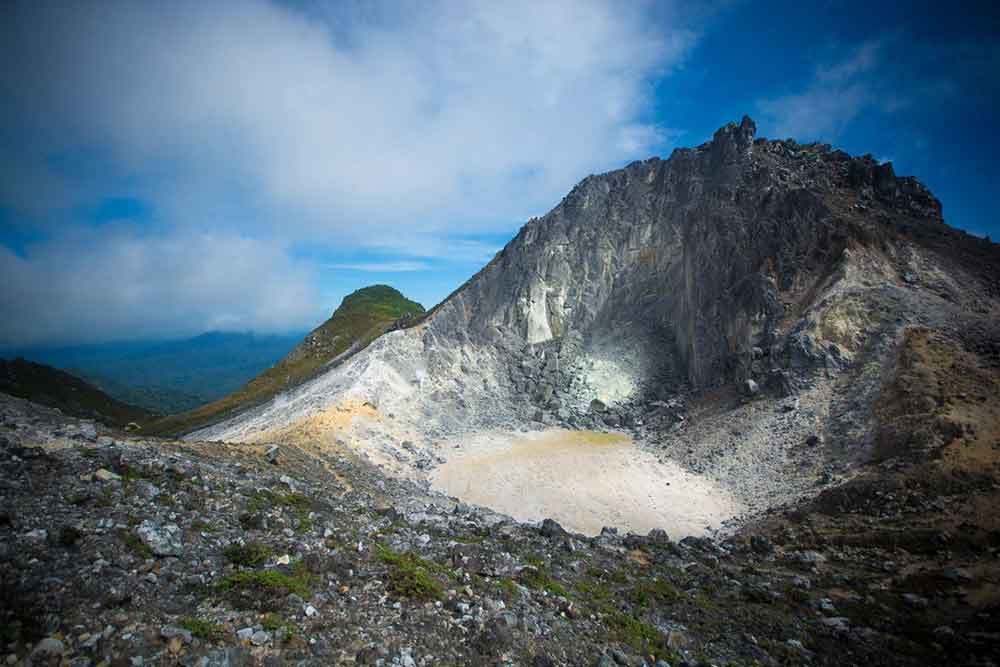 Mount Sibayak, North Sumatra features a rugged terrain with a small brown lake at the middle