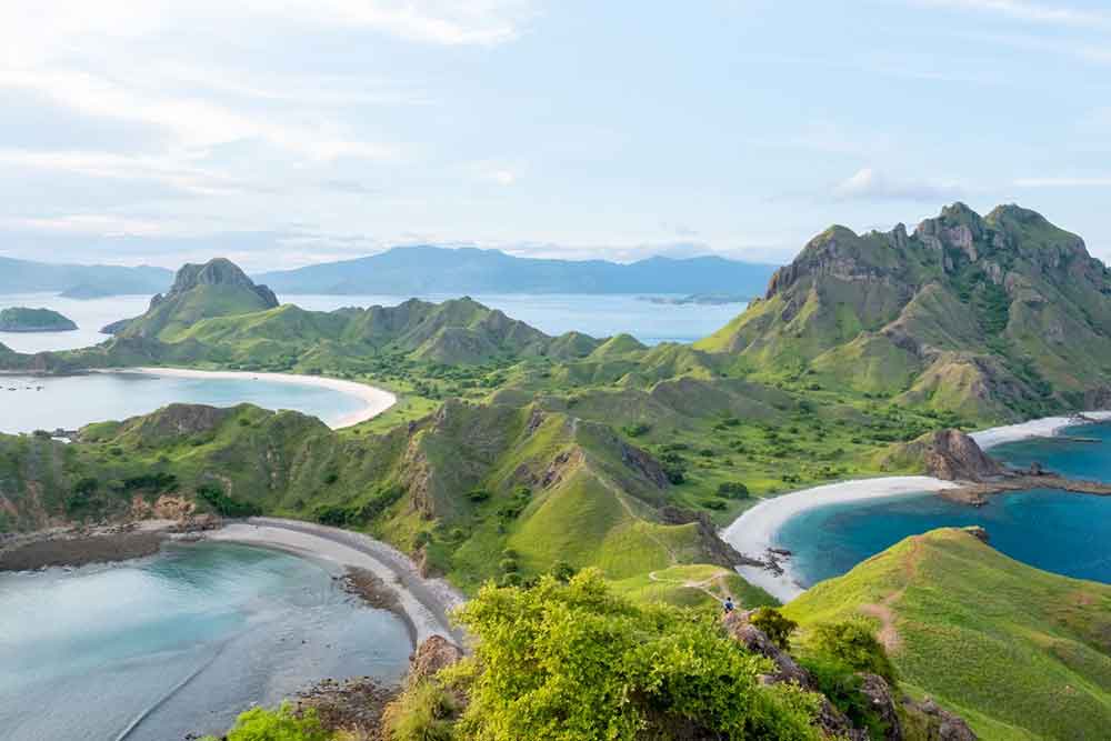Komodo Islands, Flores featuring rugged hills, rocky cliffs and pristine beaches with blue sky in a background