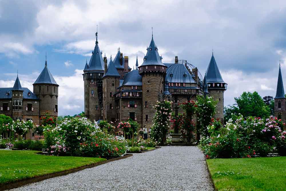 De Haar Castle, Netherlands stands as grand showcases a blend of architectural styles, towering walls, elegant spires and numerous turrets surrounded by a well-manicured garden