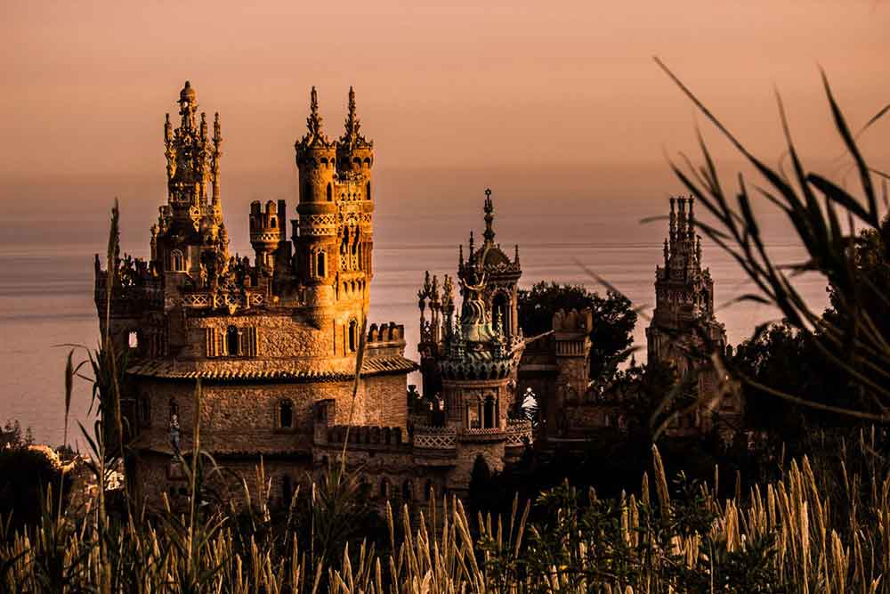 Castillo de Colomares in Spain showcases beautiful spires, intricate walls, and towers, especially stunning during sunset