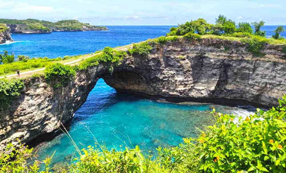 Broken Beach in Bali with high steep rock and blue water