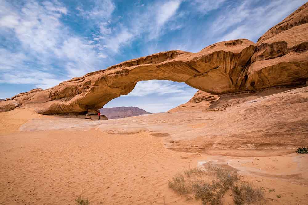 7 Best Wadi Rum Jeep Tours, Jordan: Choosing the Best 4x4 Wadi Rum Experience 9 Arch rock formation in Wadi Rum Desert in a blue sky background