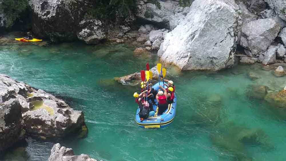 Raising our rowing equipment at the middle of white water rafting in Slovenia