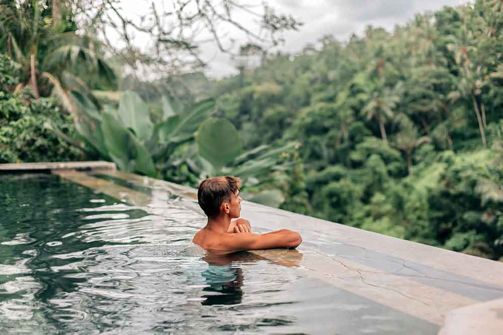 Man in an infinity pool in the Bali jungle