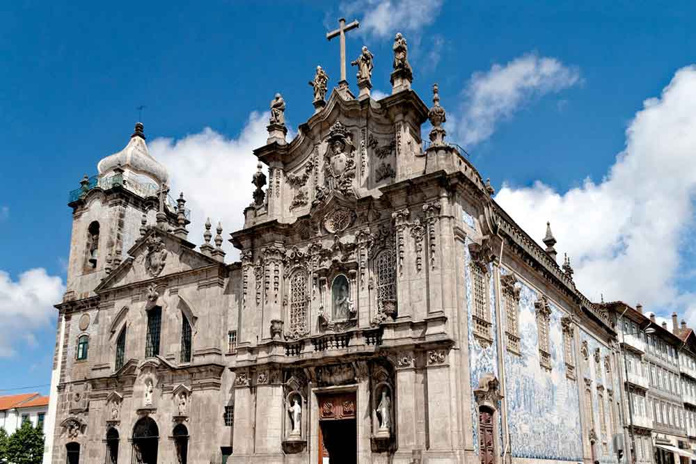 Igreja do Carmo in Porto, with its Baroque style, features grayish walls adorned with ornate details and carved statues.