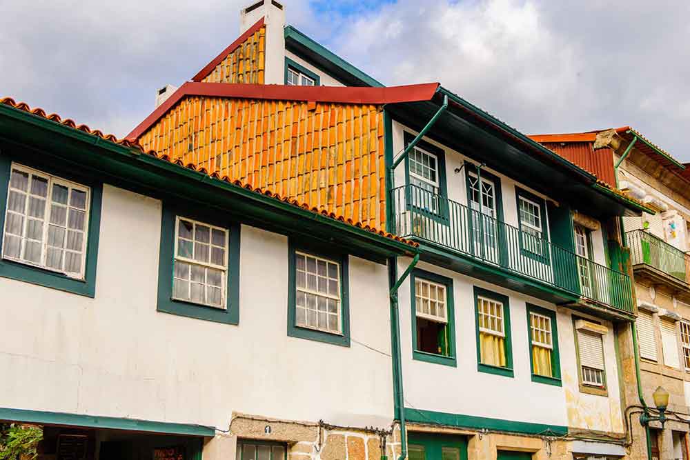 The UNESCO Town of Guimarães features a colorful houses painted in shades of orange, green, and red.