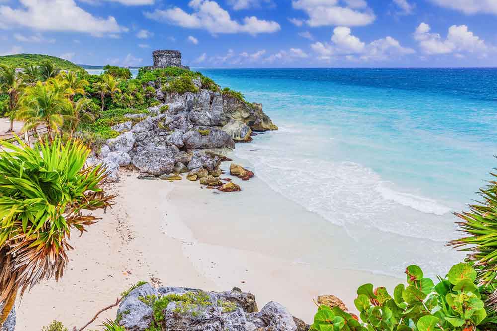 33 Best Hidden Coves and Secluded Beaches Around the World 8 Tulum Beach in Mexico presents an idyllic picture: its pristine white sands meeting the clear blue waters beneath a sky of the same hue.