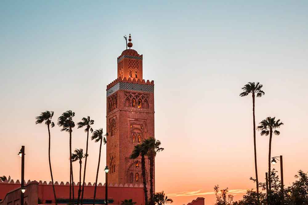 Koutoubia Mosque, Marrakech The Koutoubia Mosque in Marrakech, Morroco with its tall minaret and against the backdrop of a beautiful sunset surrounded by trees