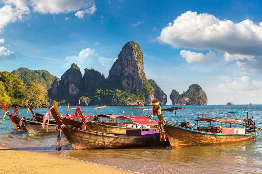 Long boats neatly parked along the shoreline in Krabi, Thailand