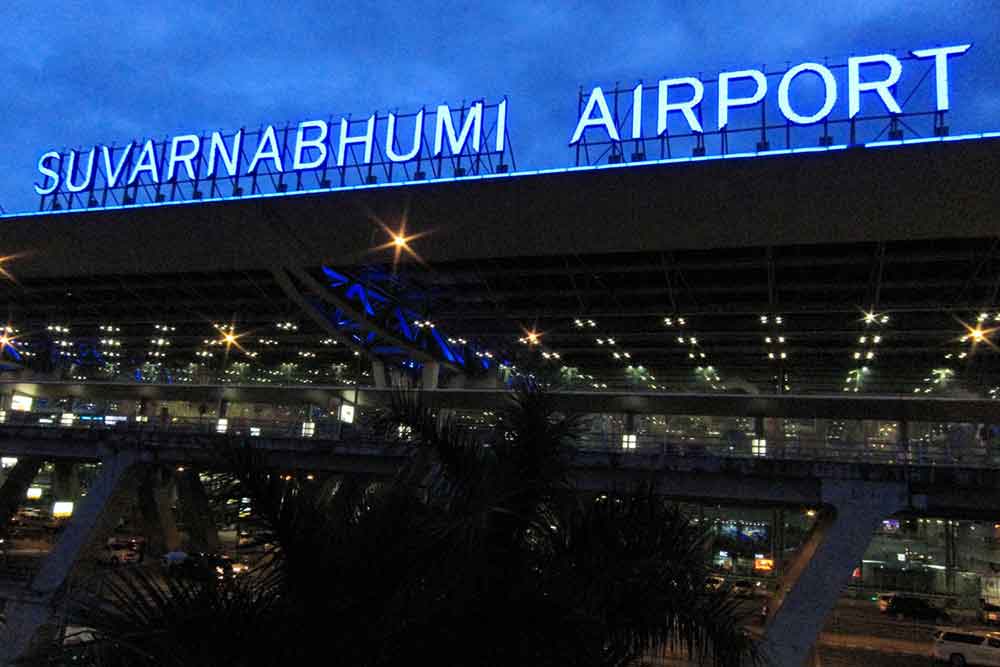 Suvarnabhumi Airport, one of Thailand's largest airports, displays its name illuminated by lights at the top of the airport roof during the night