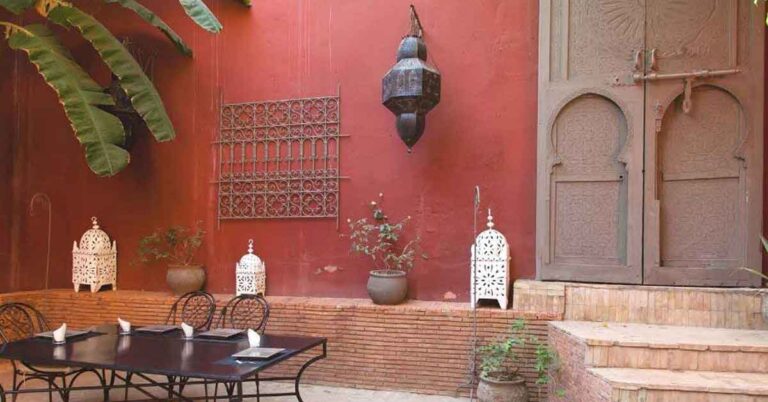 A traditional riad in morocco with red walls and decorative styling. This is the featured image for the best cheap riads in marrakech, where I give you 12 options on where to find the most affirdable riads in Marrakech and what to expect at each.