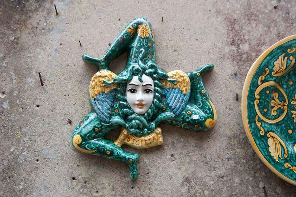 A ceramic trinacria a three leggeded person with a face in the middle, the symbol of Sicily.