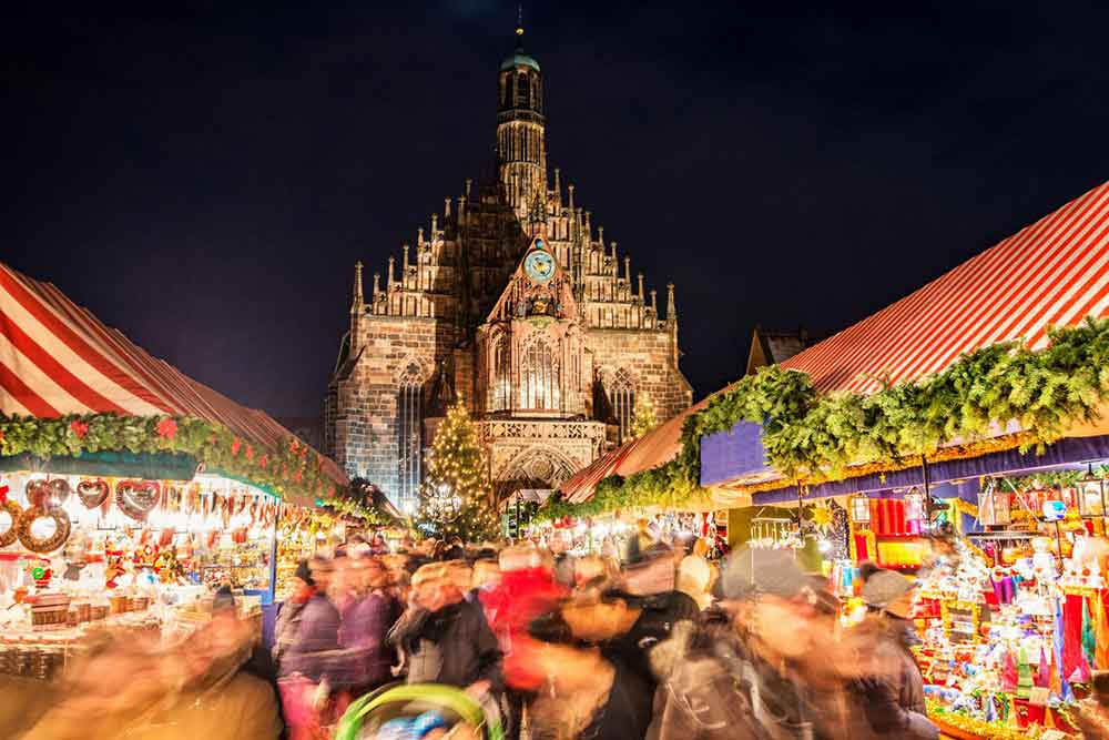 Christkindlesmarkt, Nuremberg christmas market at night time with the cathedral in the background.
