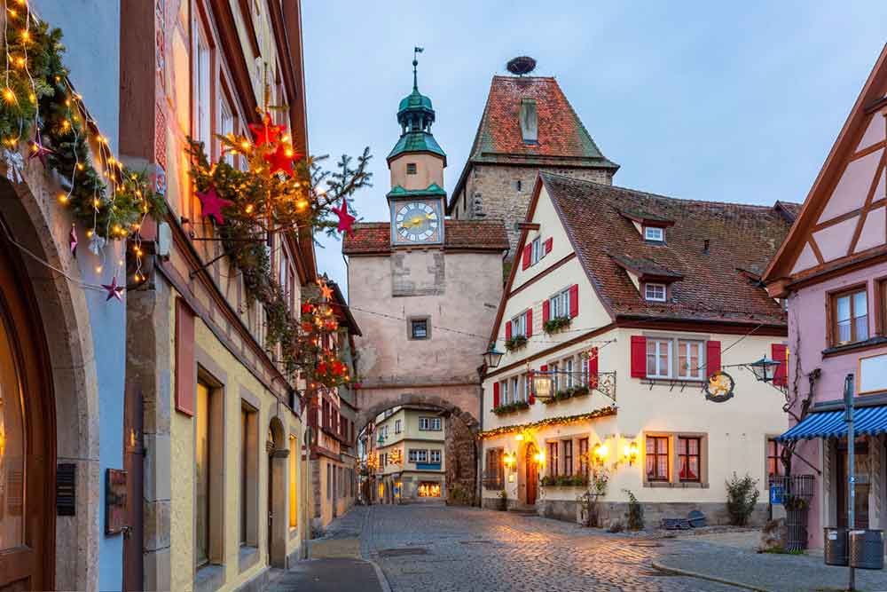 The old town of Rothenburg ob der Tauber in Germany with Christmas decorations on the walls and lights. 