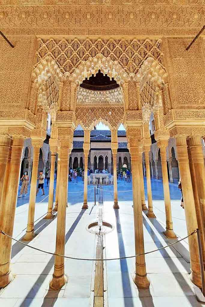 The Nasrid Palaces at the Alhambra in Granada, Spain. White markble columns in a white marble couryardwith decorative lattice work stretched between the coloumns. A definate must see during 2 days in Granada