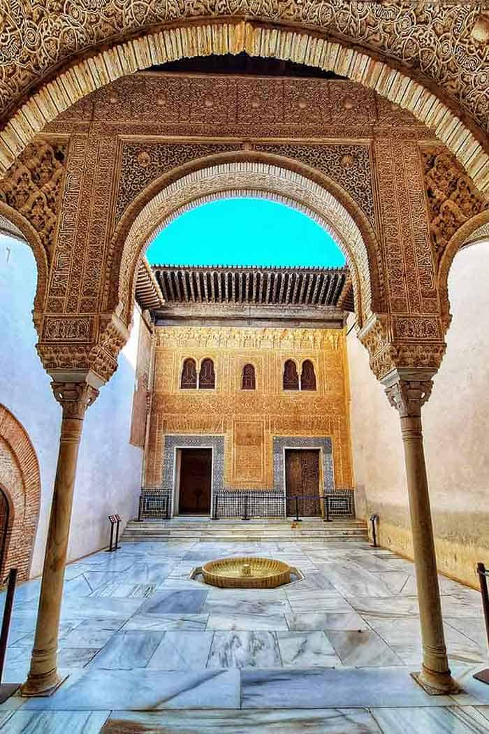Intricately carved Moorish arches and marble courtyard inside the Alhambra Palace in Granada—one of Spain’s most iconic historical monuments.