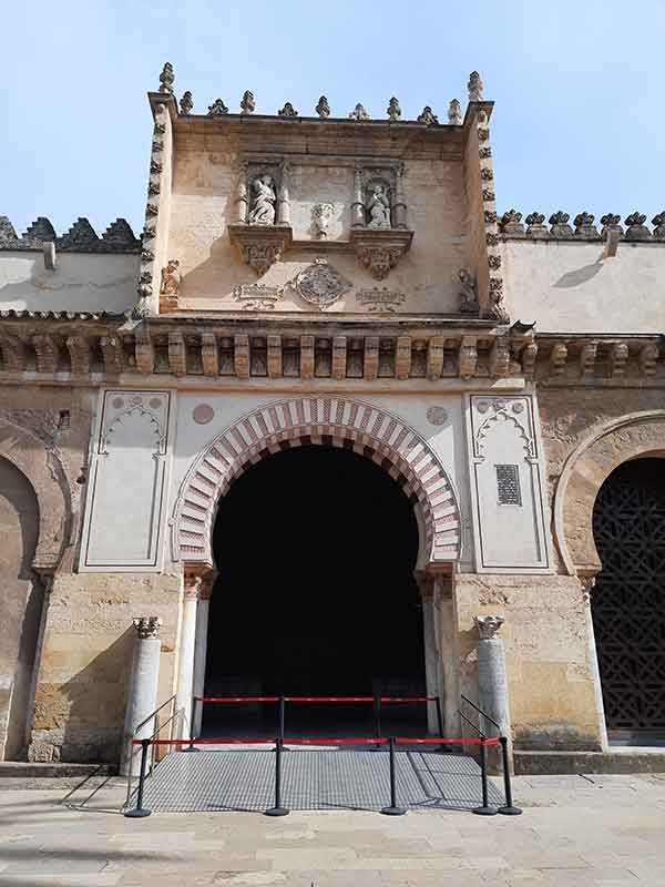 The Best Cordoba in One Day Itinerary 10 Entrance to the Mezquita ith a large arched door.