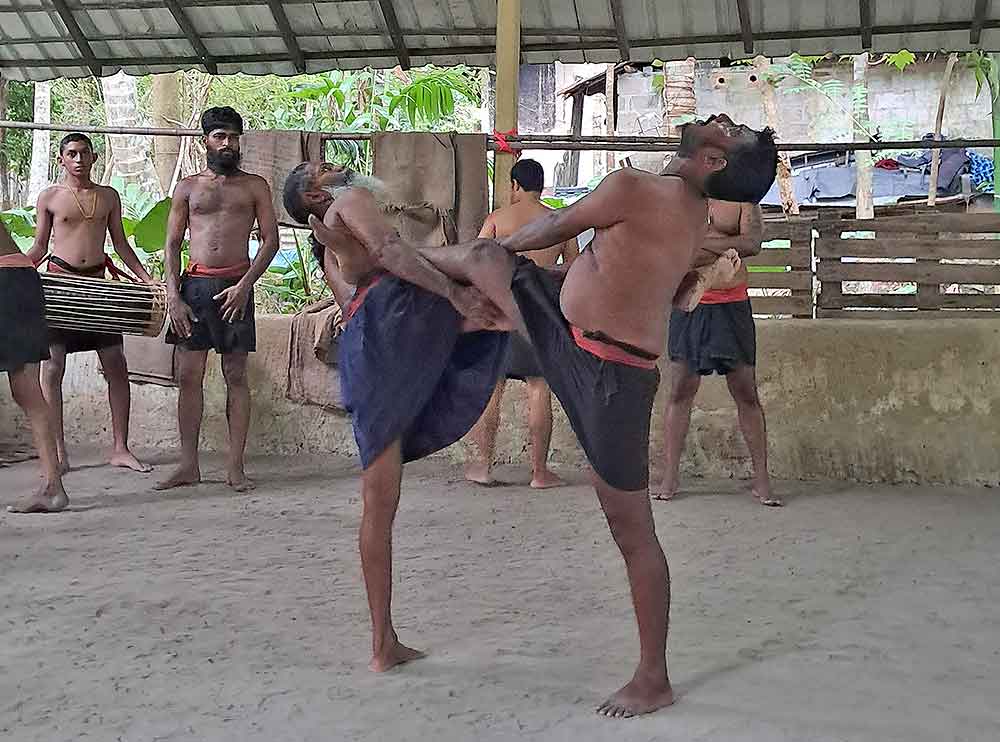 Two men with their legs intertwined performing angamapora.