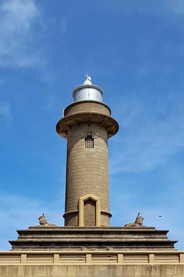 The round Colombo Galbokka Lighthouse stands on a plinth with two lions at the base.