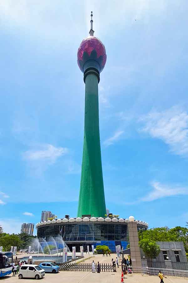View looking up at the Colombo Lotus Tower. A tall green column with a glass lotus bud shape at the top. 