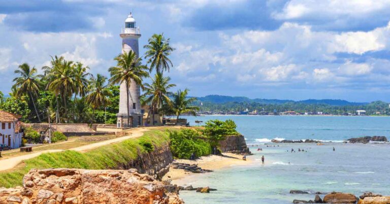 image of the lightouse in galle fort surrounded by pal trees. This is the featured image for an article about how to plan a trip to sri lanka.