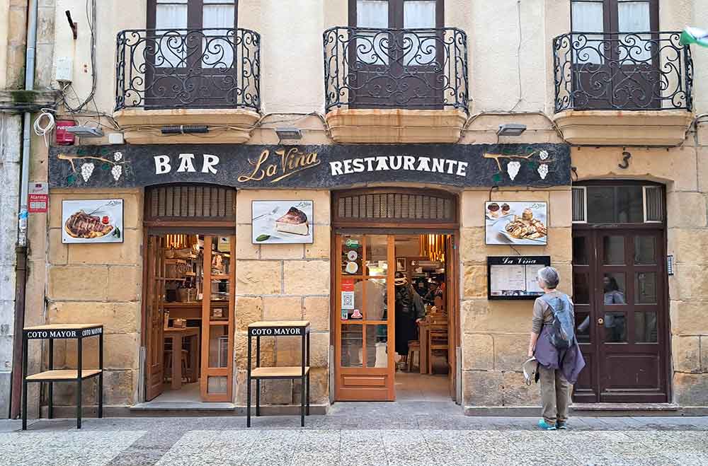 A cozy restaurant facade in San Sebastian, known for serving the original Basque cheesecake, which is an iconic dish that helps define what San Sebastian is known for in culinary circles.