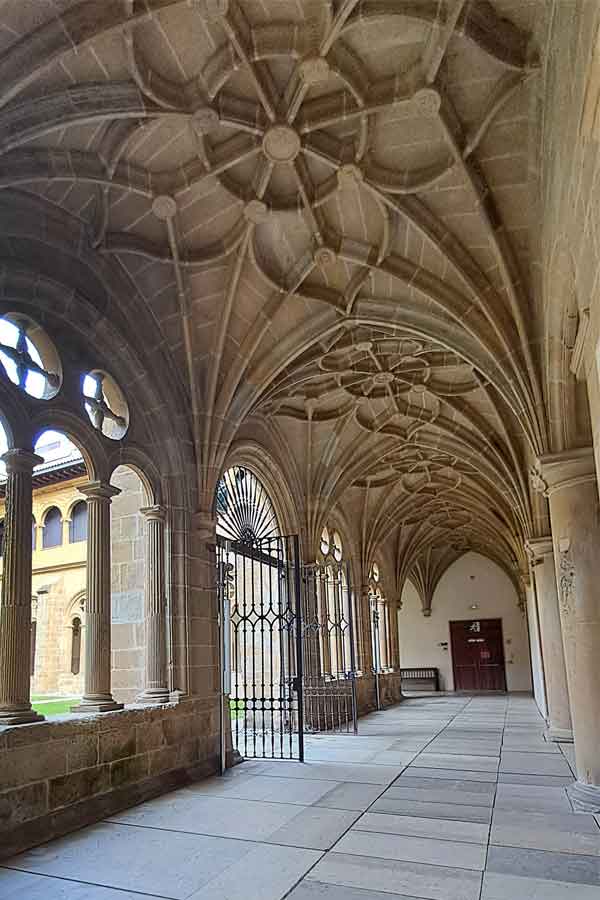 The Cloister at San Telmo Museum with a decorative ceiling and arched windows opening into a grassy centre. 