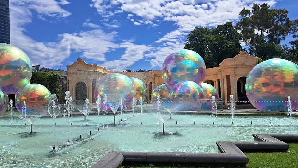 The Pavillion at Parque Doña Casilda Iturrizar with a fountain in front. There's a temporry exhibition of giant bubbles stacked on the ground in front. 