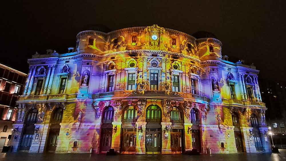 The Illumination of Teatro Arriaga during Gau Zuria event with colourful images projected onto the building.