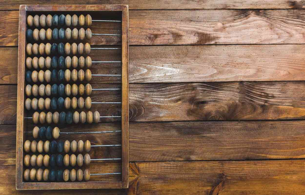 A vintage abacus with pale yellow and blue wooden beads.