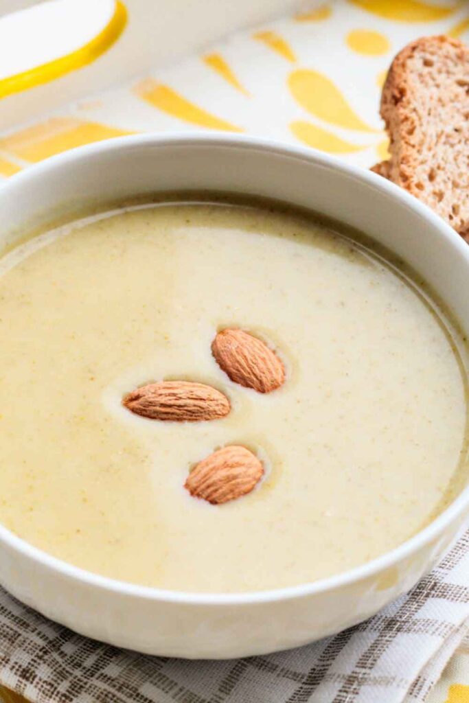 Creamy almond soup garnished with whole almonds, served with rustic bread. A traditional Andalusian dish offering a cool take on vegetarian fare.
