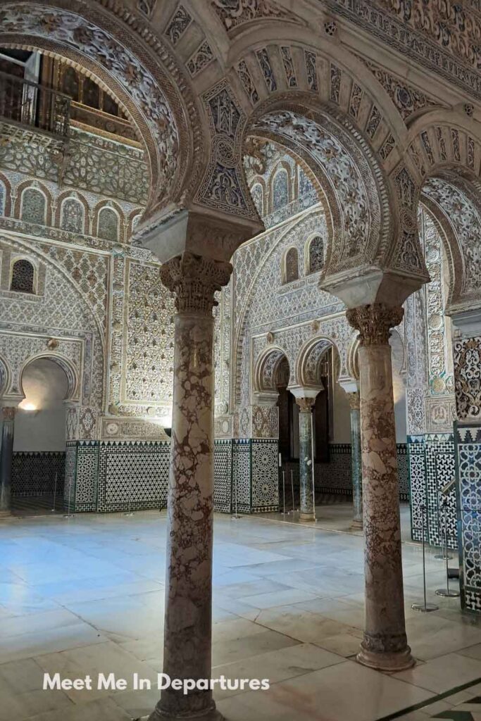 Intricately carved arches and marble columns in the Salón de los Embajadores at the Real Alcázar of Seville, showcasing elaborate Mudejar tilework and stucco patterns, photographed during a VIP tour.
