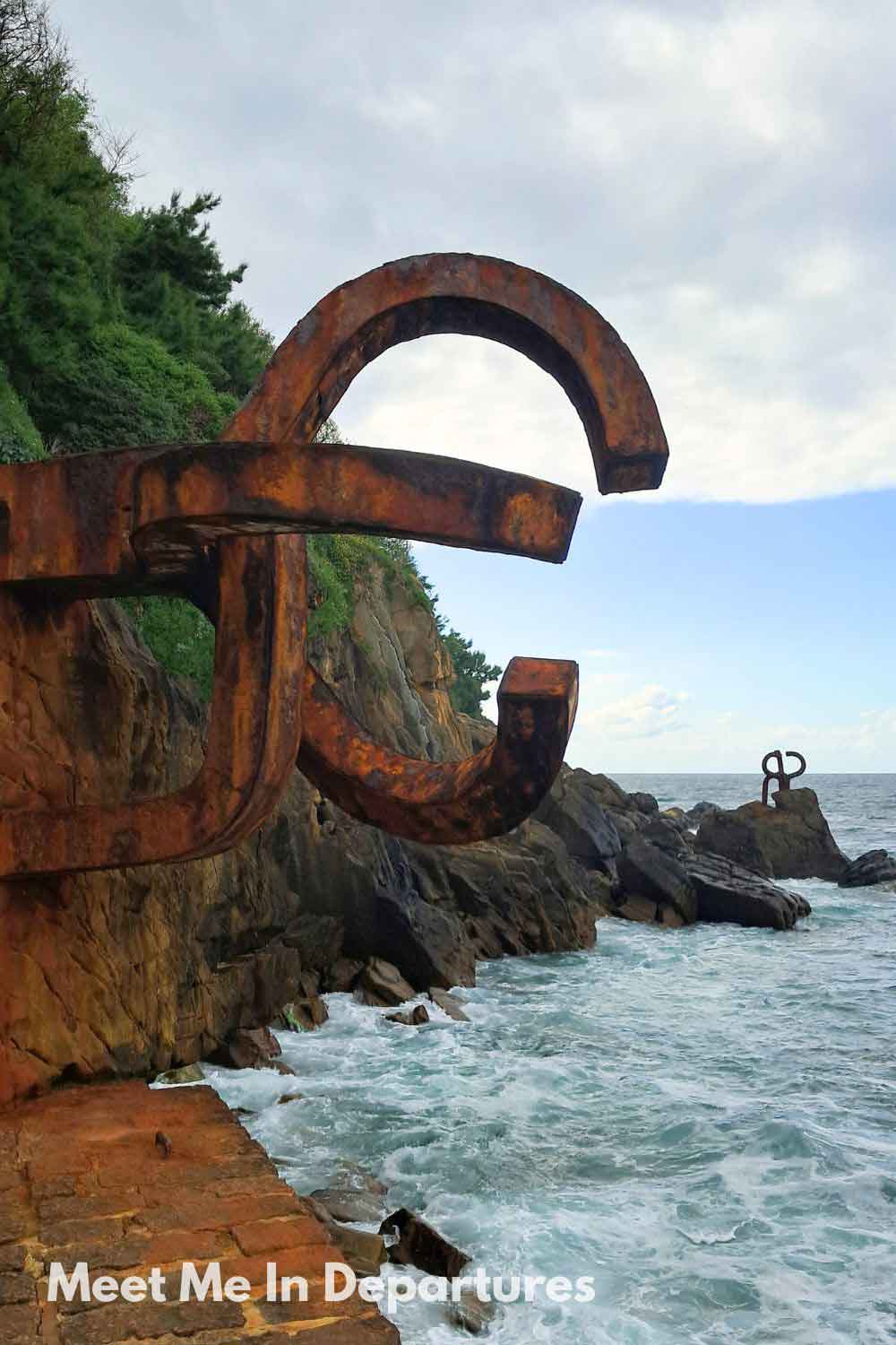 Rusted steel sculptures of the Peine del Viento on the rocky coastline of San Sebastian, a famous Basque landmark blending art and nature.