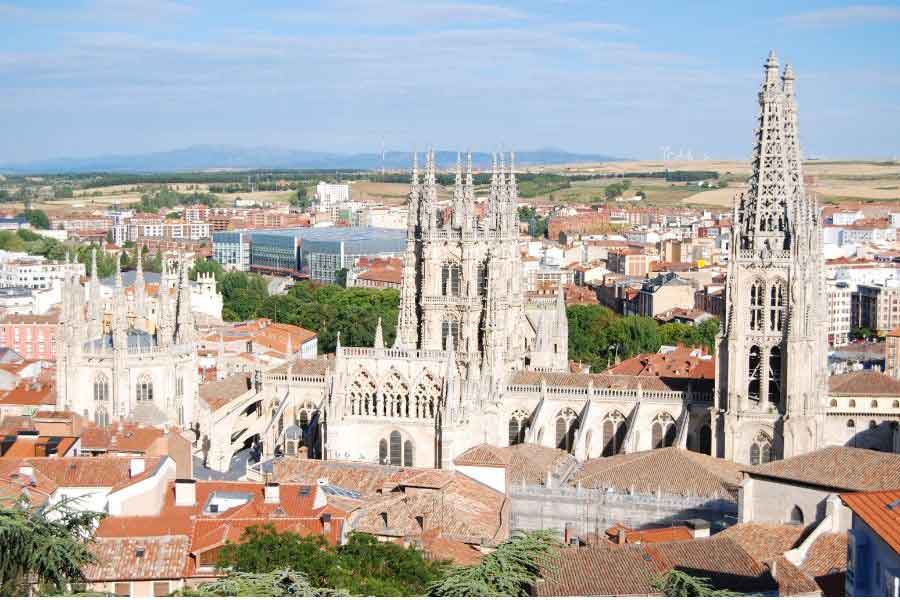Aerial view of Burgos Cathedral with its towering Gothic spires rising above the city, a UNESCO-listed landmark on the Camino de Santiago route in northern Spain.