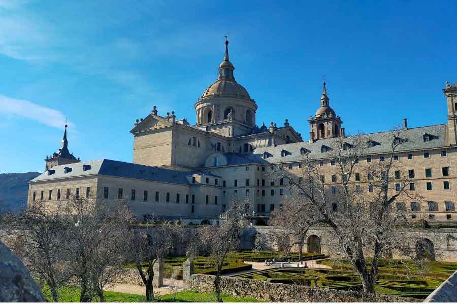 Exterior view of the Monastery of San Lorenzo de El Escorial near Madrid, a grand Renaissance complex that includes a palace, library, and royal mausoleum.
