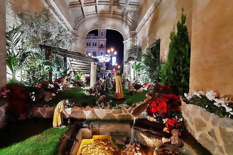 Seville Town Hall Nativity Scene Nativity scene displayed at Seville Town Hall during Christmas, featuring detailed figures, poinsettias, and soft lighting that creates a warm festive atmosphere in the city centre.