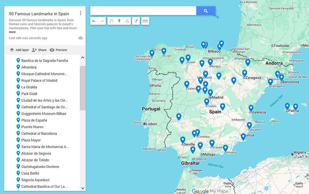 A famous landmarks of Spain map showing the locations of 50 iconic sites across the country, including cities like Madrid, Barcelona, Seville, Granada, and Bilbao, marked with blue pins on a Google My Maps layout.