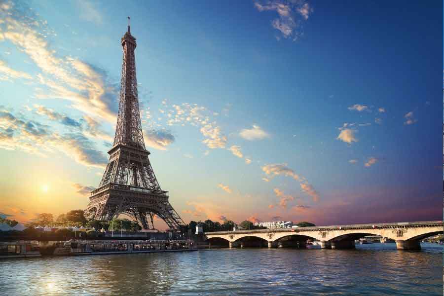 The Eiffel Tower and the River Seine in Paris at sunset, one of Europe’s most timeless dream travel destinations for romance and sightseeing.