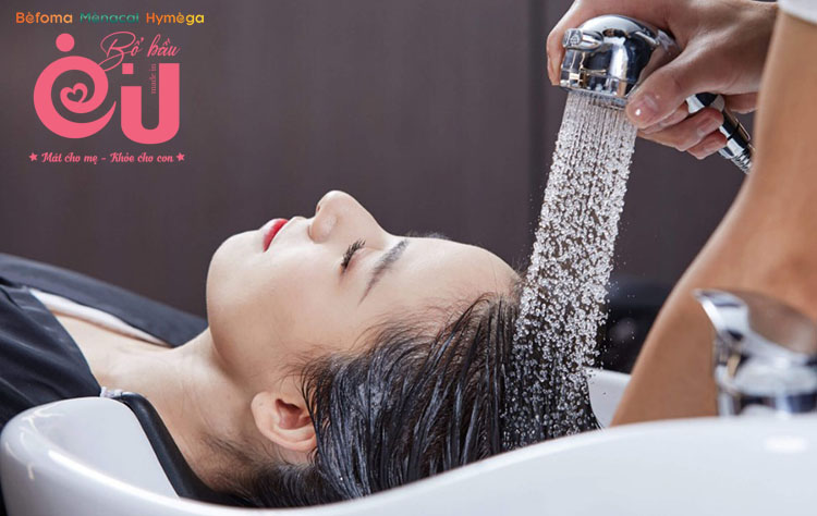Mẹ cần gội đầu nhanh với nước ấm để không bị nhiễm lạnh