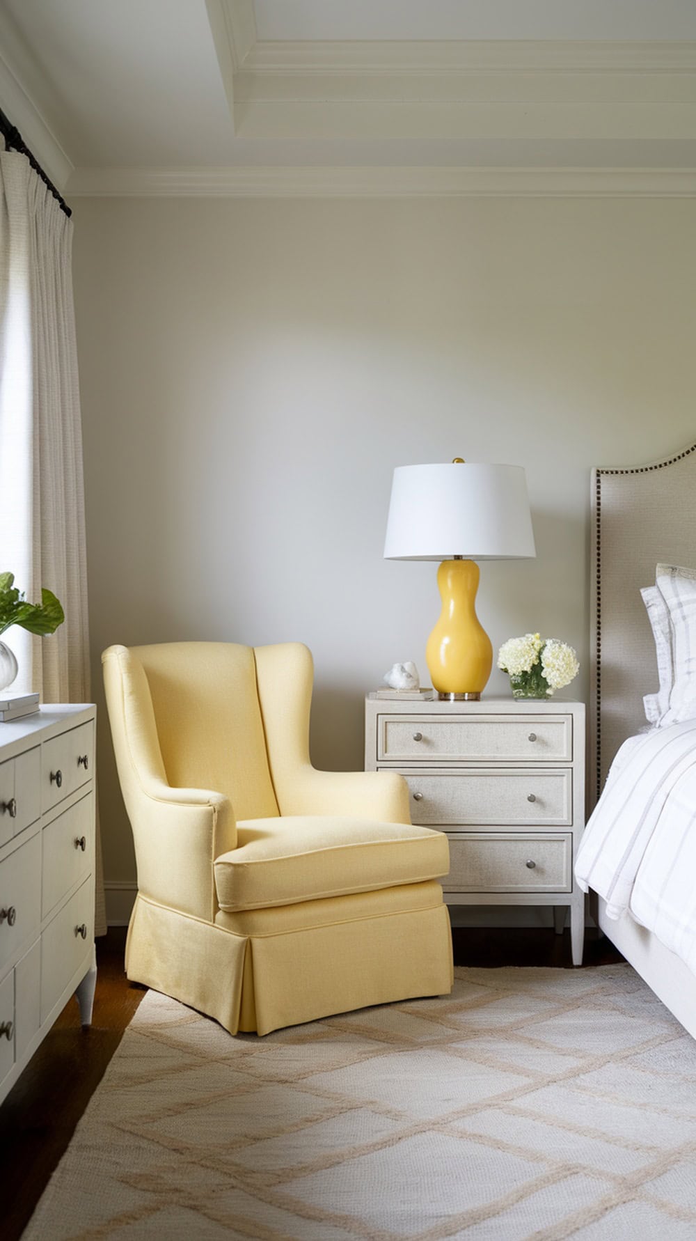 A cozy bedroom featuring lemon yellow accent furniture, including a chair and lamp, against neutral tones.