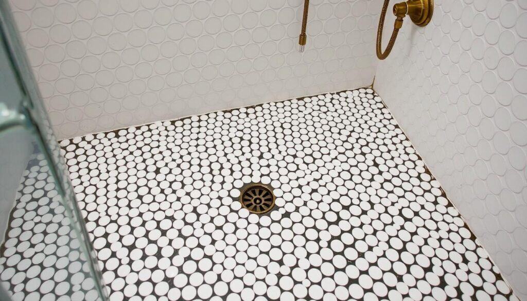 White penny round tiles on a shower floor with vintage fixtures