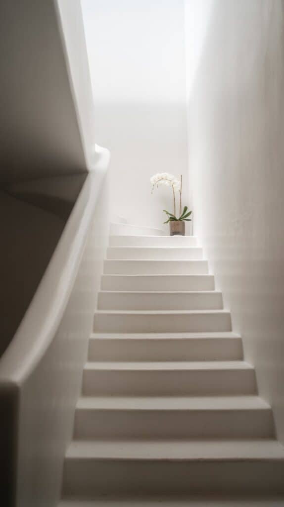 All-white staircase with a white wall, white handrail, and white steps for a soft, seamless effect.